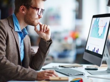 man in suit looking at computer screen